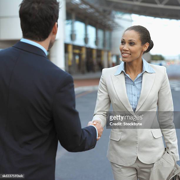 close-up of two business executives shaking hands - open roads world premiere of mothers day arrivals stockfoto's en -beelden