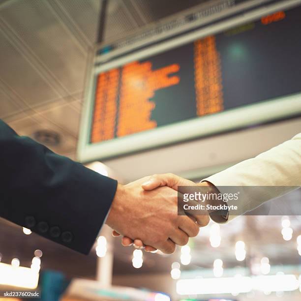 close-up of two business executives shaking hands - open roads world premiere of mothers day arrivals stockfoto's en -beelden