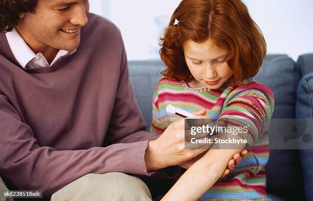 close-up of a man injecting a young girl (8-10) in the arm - genderblend stock pictures, royalty-free photos & images