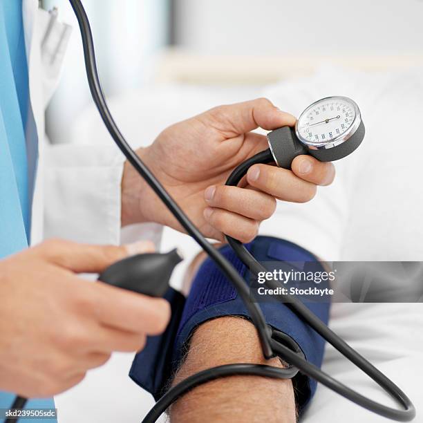 close-up of doctor taking blood pressure of patient - rapporto medico paziente foto e immagini stock