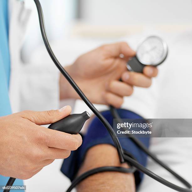 close-up of doctor taking blood pressure of patient - rapporto medico paziente foto e immagini stock