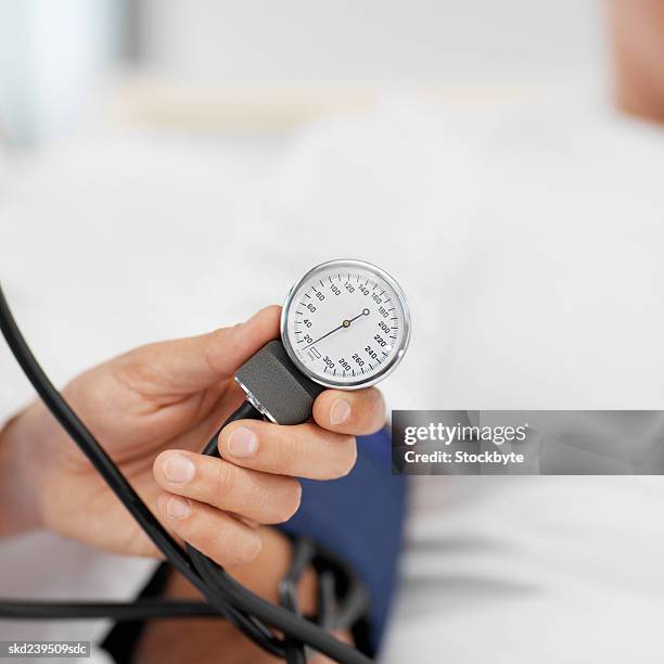 close-up of doctor taking blood pressure of patient - rapporto medico paziente foto e immagini stock
