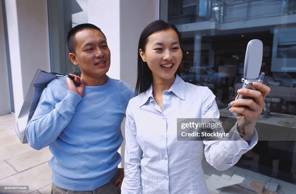 Portrait of a young couple looking at a mobile phone screen