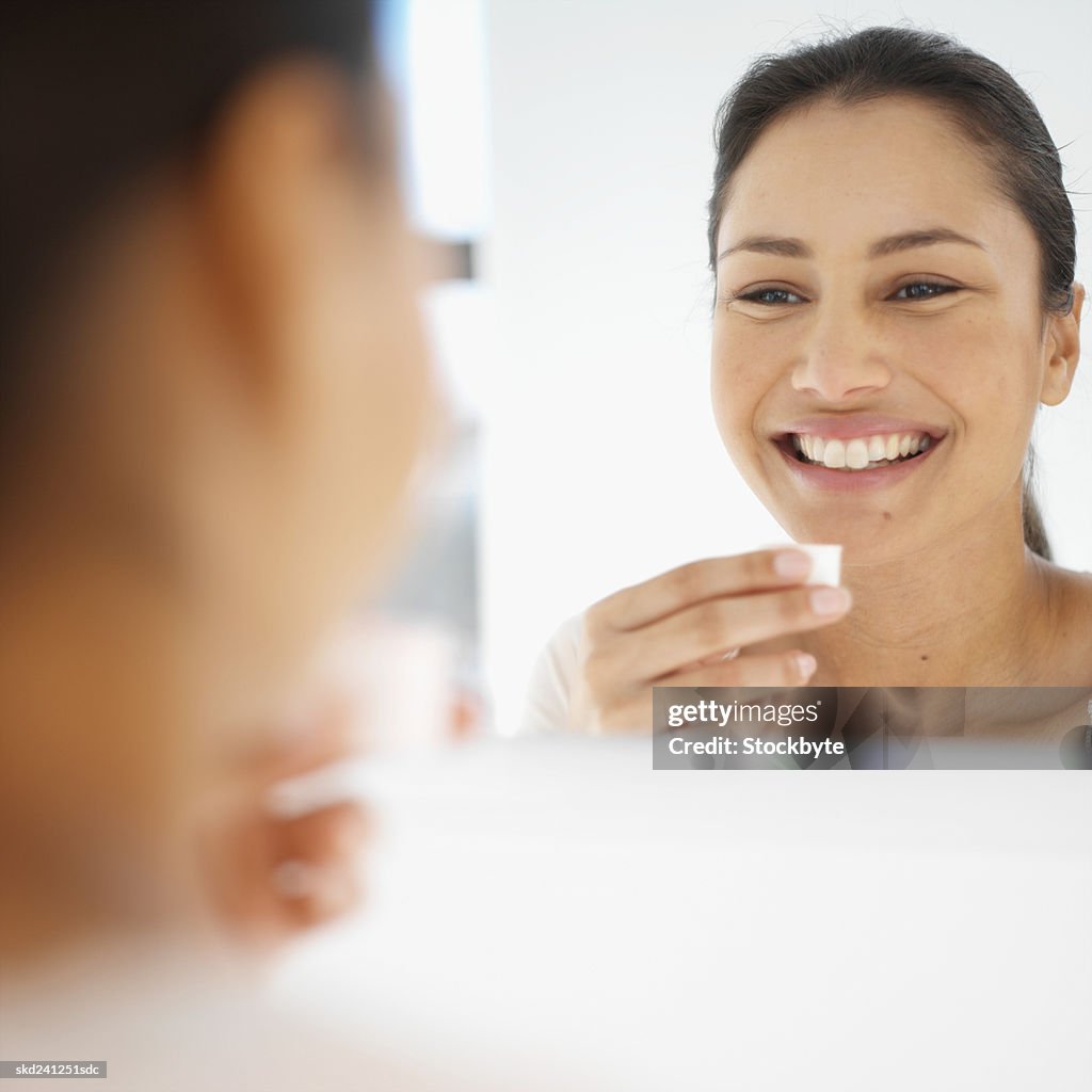 Close-up of young woman rinsing her mouth with mouthwash