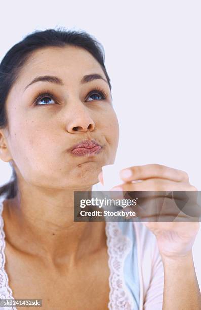 woman gargling and holding a cup of mouthwash - mouthwash stock-fotos und bilder