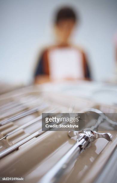 close-up of a tray of dental equipment with a young boy in the background (blurred) - ツール ストックフォトと画像
