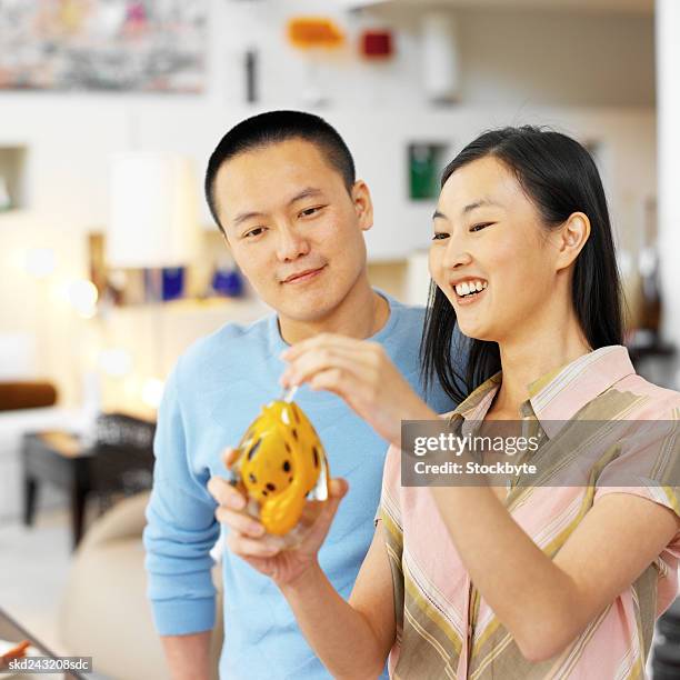 young couple admiring a piece of home ware - ware stock pictures, royalty-free photos & images