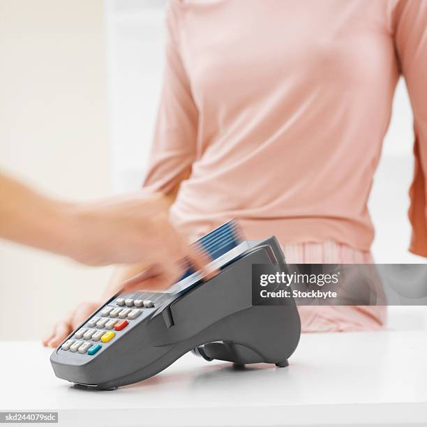close-up of woman's hand scanning credit card through credit card reader - e reader - fotografias e filmes do acervo
