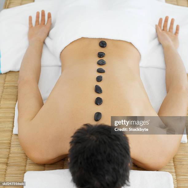 man receiving lastone therapy - menselijke rug stockfoto's en -beelden