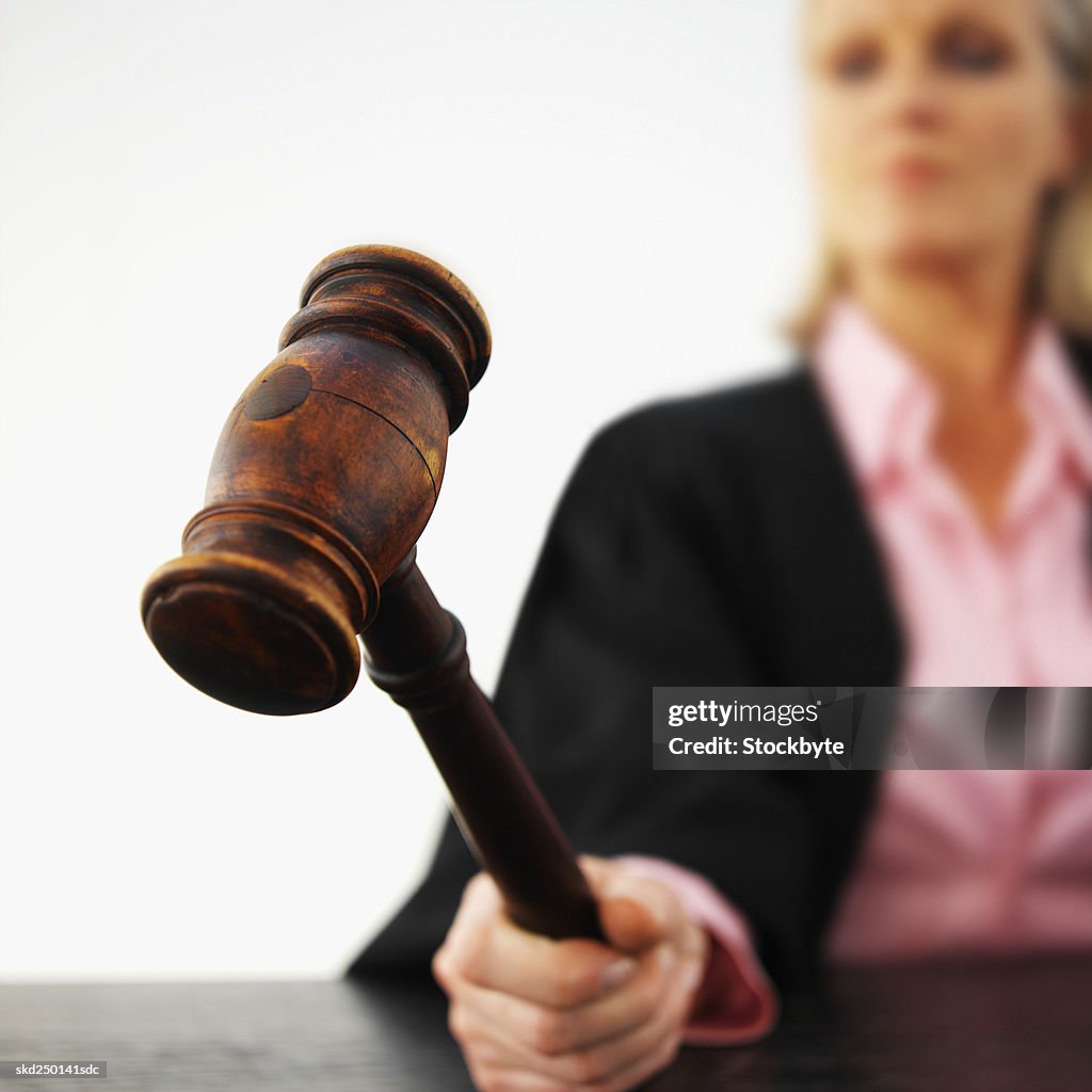 Close-up of female judge banging gavel