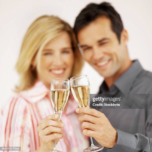 front view portrait of mid adult couple holding glasses of champagne - dark haired man gray shirt with wine stock pictures, royalty-free photos & images