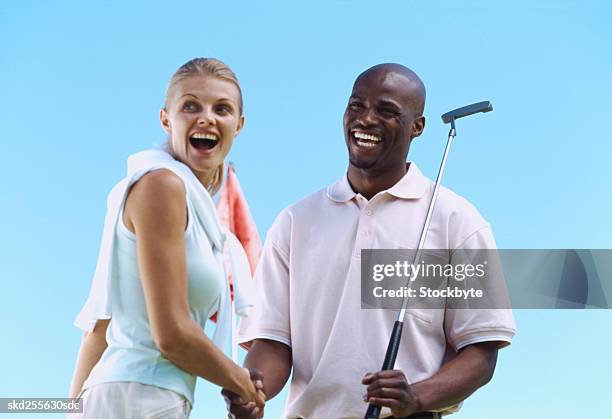 low angle view of a young couple shaking hands after a round of golf - after stock pictures, royalty-free photos & images