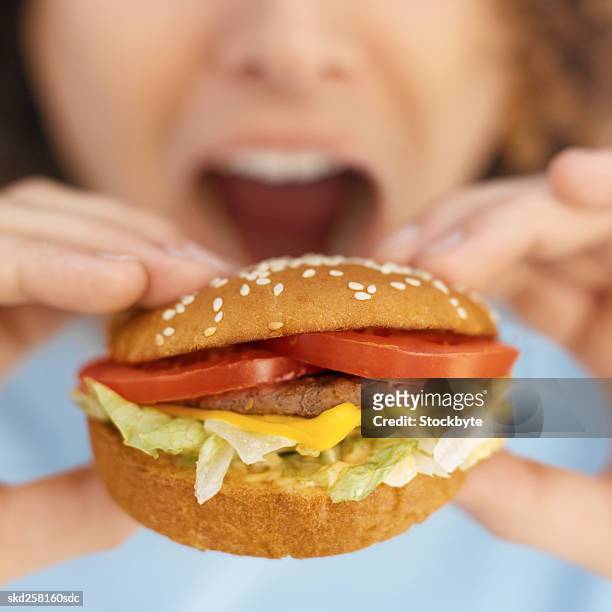 front view portrait of young man eating burger - taste of john paul ataker presentation spring 2016 new york fashion week stockfoto's en -beelden