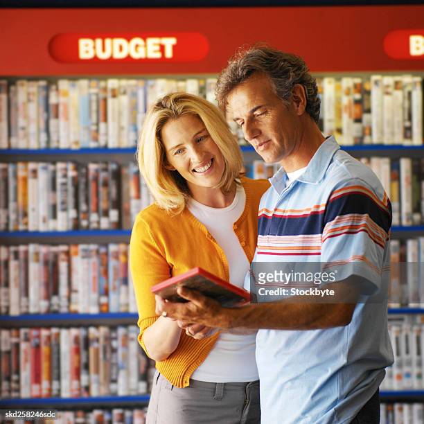 close-up of couple looking at dvd in video shop - dvd fodral bildbanksfoton och bilder