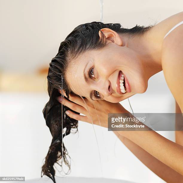 close-up of a woman rinsing her hair - haar wassen stockfoto's en -beelden