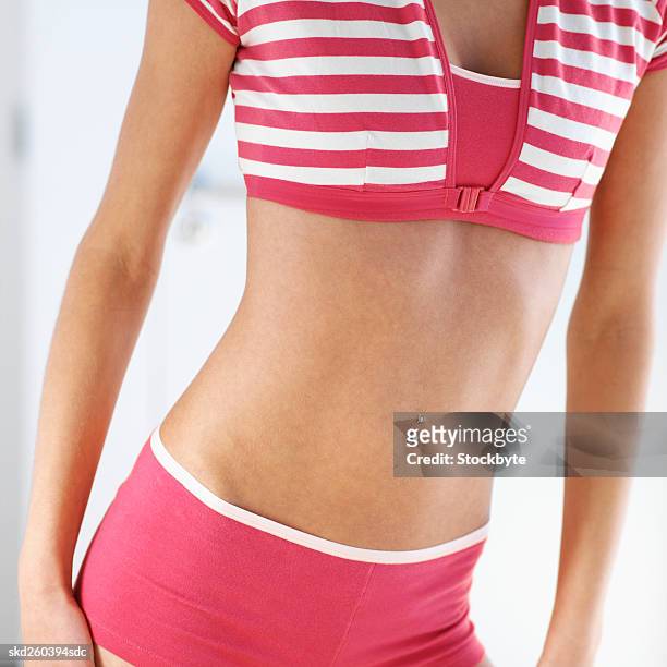 close-up mid section of a woman standing - belly ring stock pictures, royalty-free photos & images