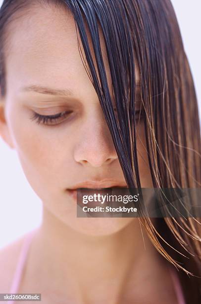 close-up of a young woman's face with wet hair falling across it - falling stock-fotos und bilder