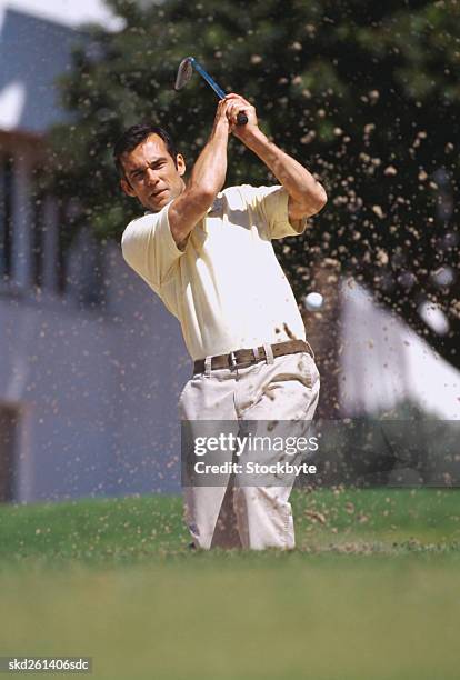young man swinging a golf club at a golf course - golf club - fotografias e filmes do acervo