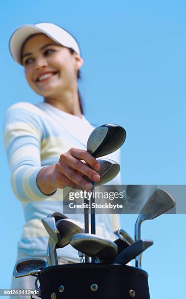 low angle view of a woman removing a golf club from a bag - golf club - fotografias e filmes do acervo