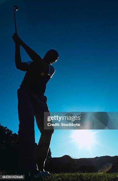 low angle view of a male golfer about to hit a drive - about stock pictures, royalty-free photos & images