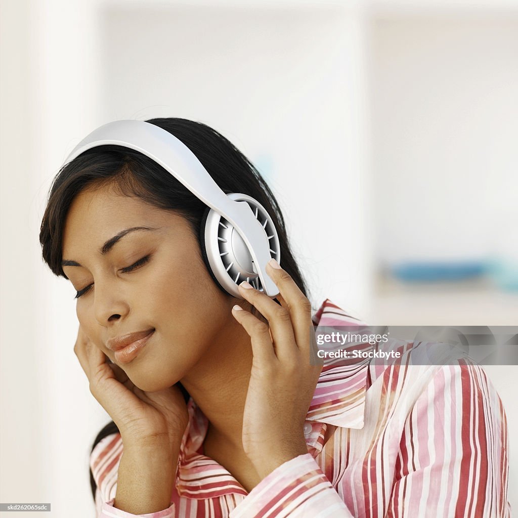 Close-up of young woman listening to music with headphones