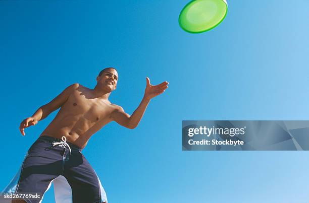 close-up of young man throwing plastic disc - compacted stock pictures, royalty-free photos & images