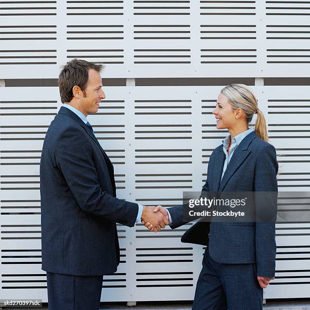 handshake between a businessman and businesswoman - between stock-fotos und bilder