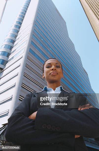 low angle view of a young businesswoman standing near a high rise building - high and low stockfoto's en -beelden