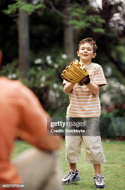 father and son playing baseball in garden (10-11) - catchers mitt stock pictures, royalty-free photos & images