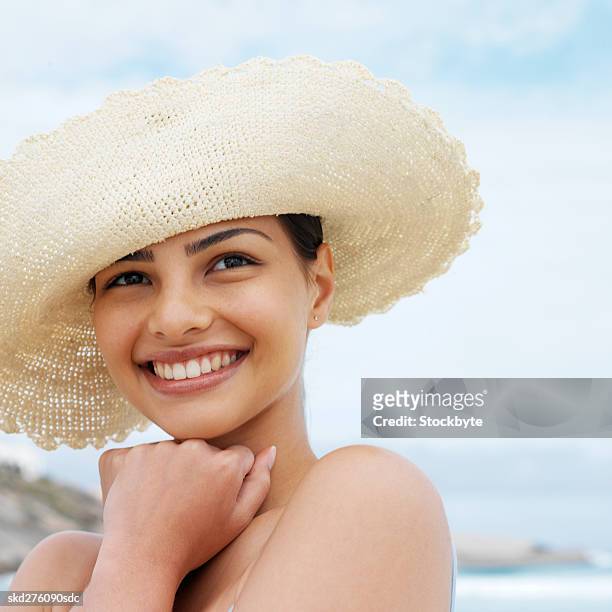 close-up of a woman wearing hat at beach - hat stock-fotos und bilder