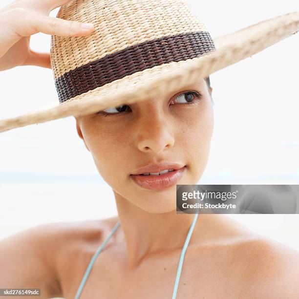 close-up of a woman wearing hat at the beach - hat stock-fotos und bilder