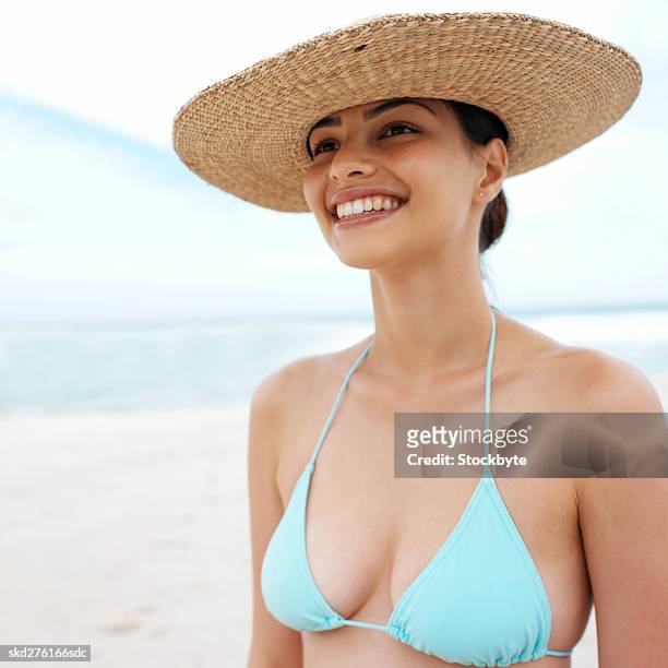 close-up of a woman wearing hat at the beach - hat stock-fotos und bilder