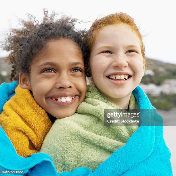 close-up of two girls with towel wrapped around them (10-11) - envuelto en una toalla fotografías e imágenes de stock