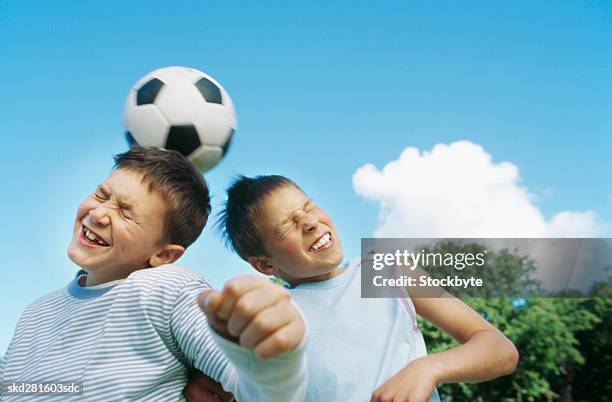 boys (10-12) playing football - heading stock pictures, royalty-free photos & images