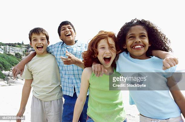 four happy children together on a beach - 13 year old girls in shorts stock pictures, royalty-free photos & images