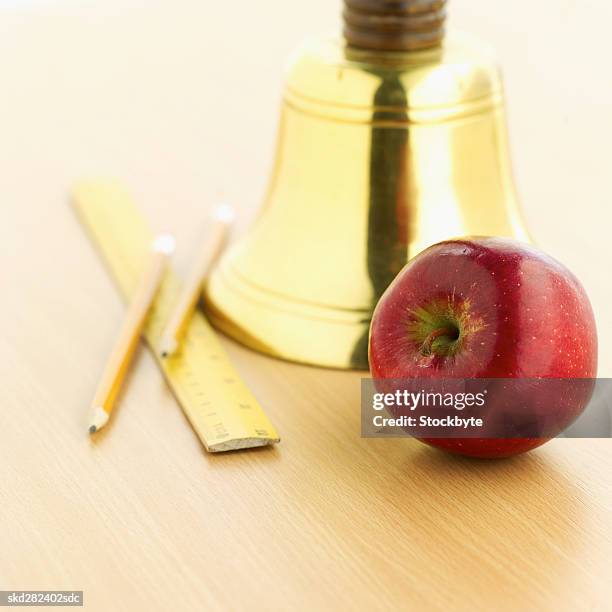 close-up of school bell and apple and stationary - bell foto e immagini stock