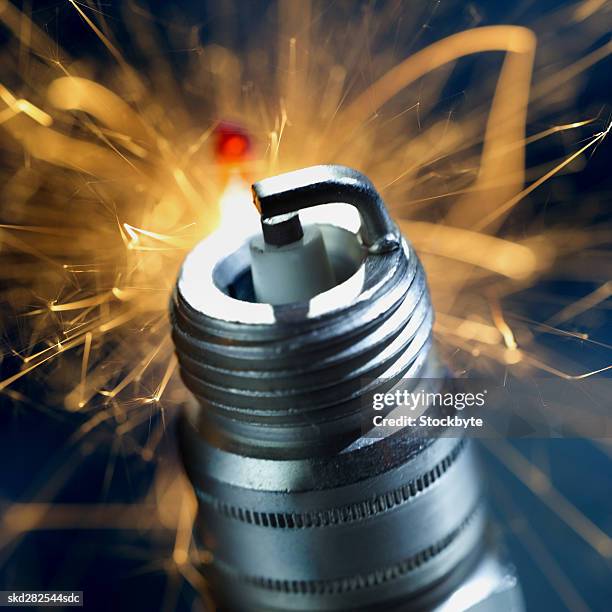 close-up of a spark plug with sparks exploding - sparks fotografías e imágenes de stock