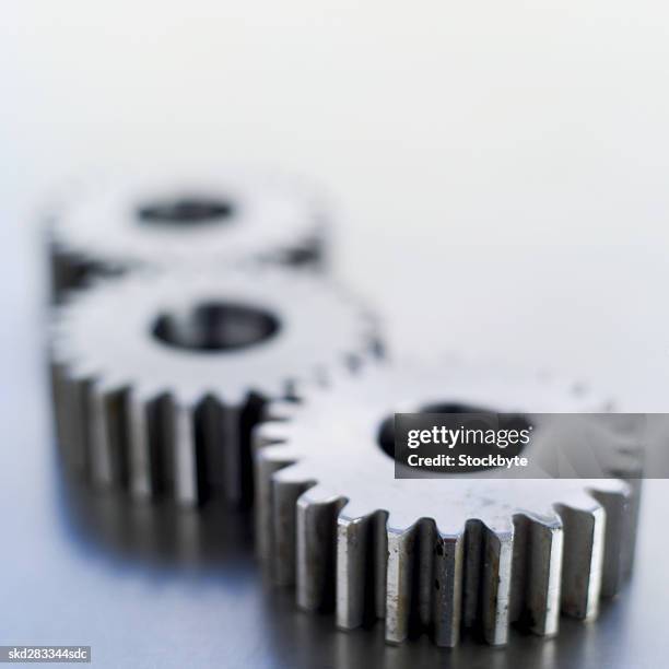 close-up of three cogs - movimiento perpetuo fotografías e imágenes de stock