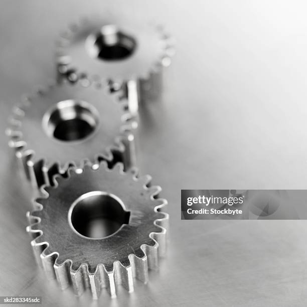 elevated view of three cogs - movimiento perpetuo fotografías e imágenes de stock
