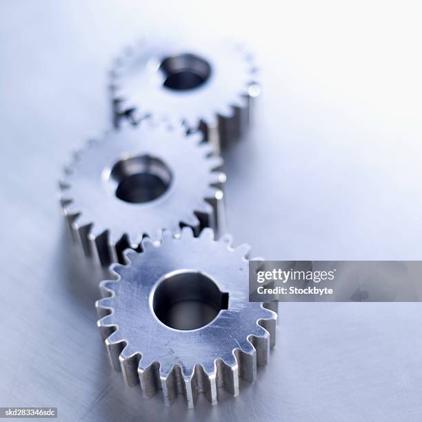 elevated view of three cogs - movimiento perpetuo fotografías e imágenes de stock