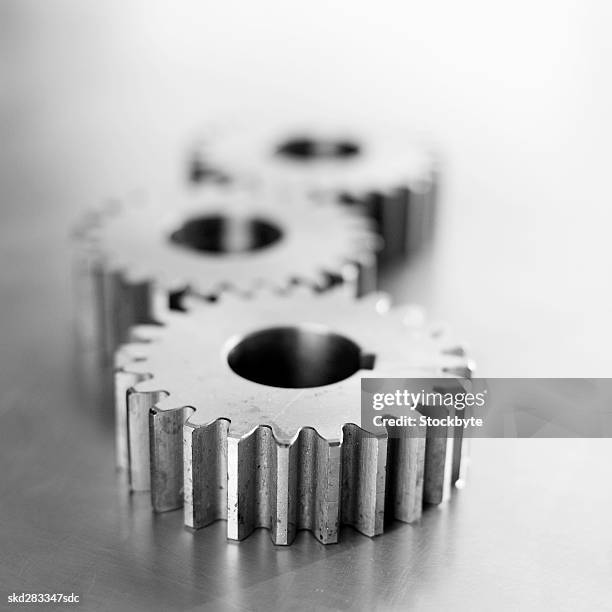 close-up of three cogs - movimiento perpetuo fotografías e imágenes de stock