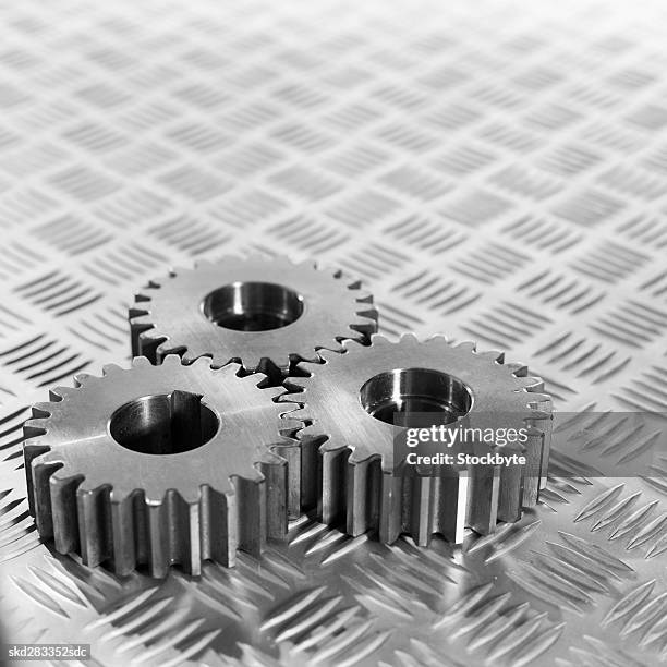 close-up of three cogs - movimiento perpetuo fotografías e imágenes de stock