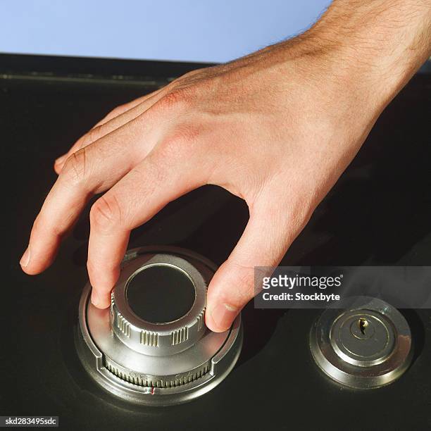 close-up of a man's hand turning combination lock - 庇護者 ストックフォトと画像
