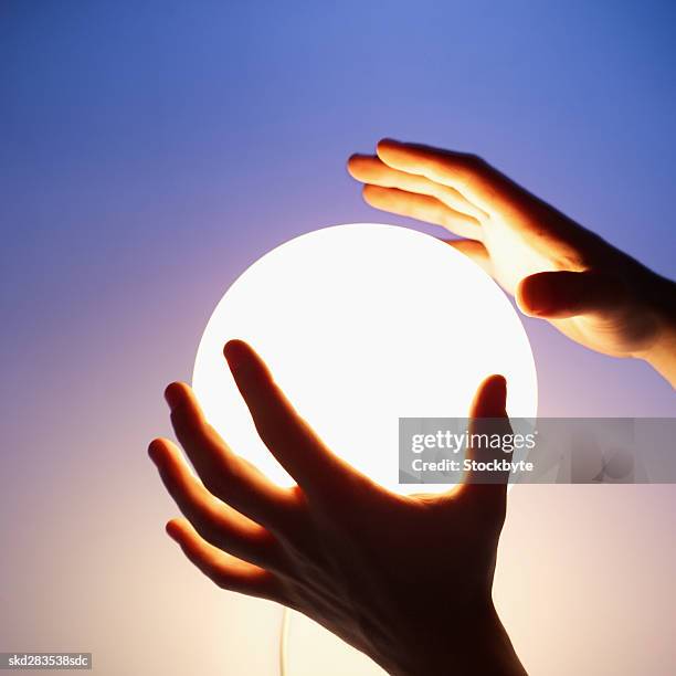 close-up of man's hands touching crystal ball - crystal stock-fotos und bilder