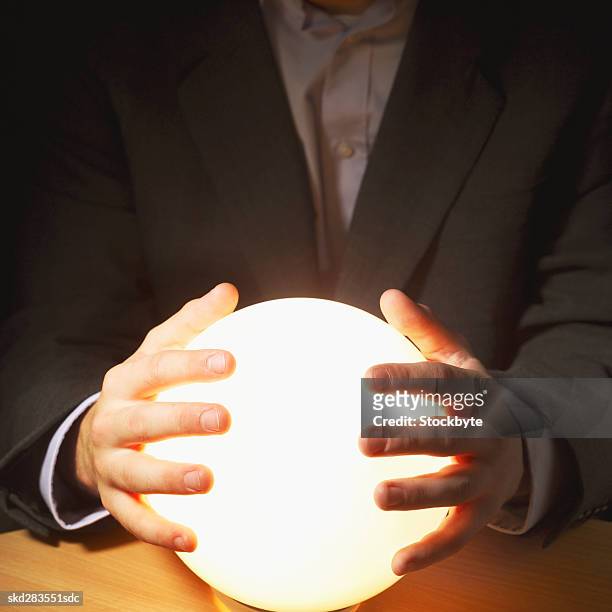 close-up mid section of man touching crystal ball - crystal - fotografias e filmes do acervo