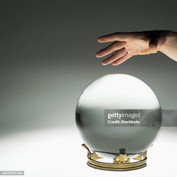 close-up of man's hand touching crystal ball - crystal stock-fotos und bilder