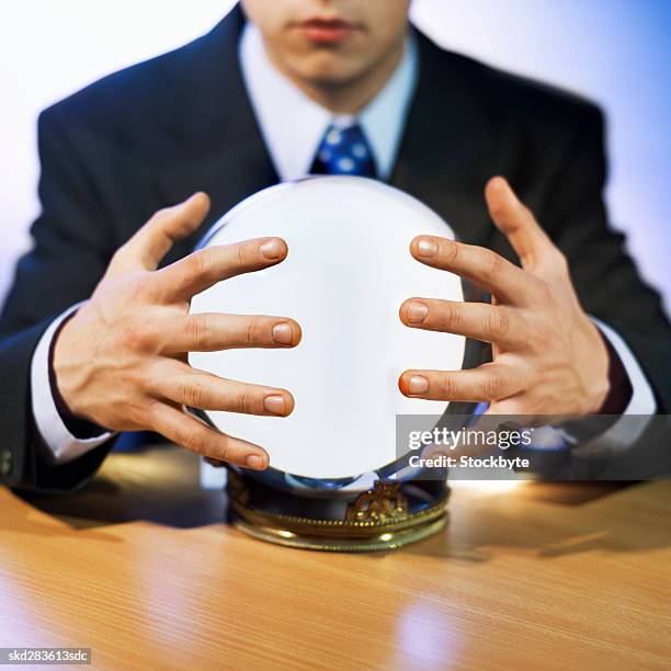 close-up mid section of man touching crystal ball - crystal stock-fotos und bilder