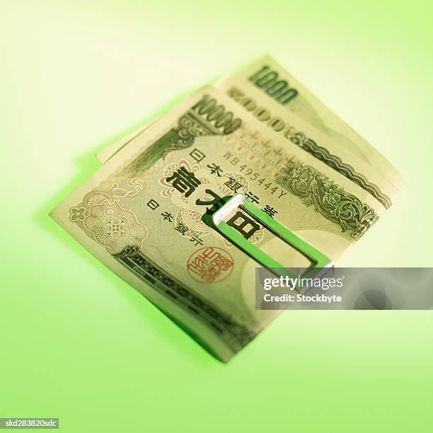 close-up of various japanese yen notes held together with clip - five thousand yen note stock pictures, royalty-free photos & images