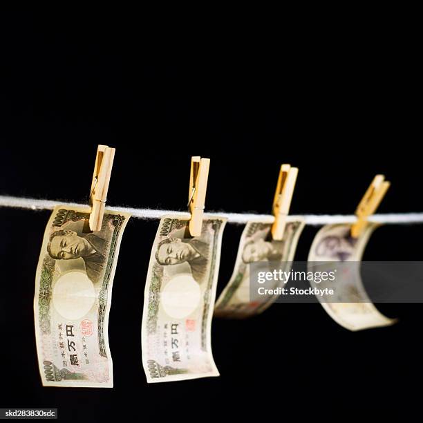 close-up of various japanese yen notes hanging on clothesline - five thousand yen note stock pictures, royalty-free photos & images