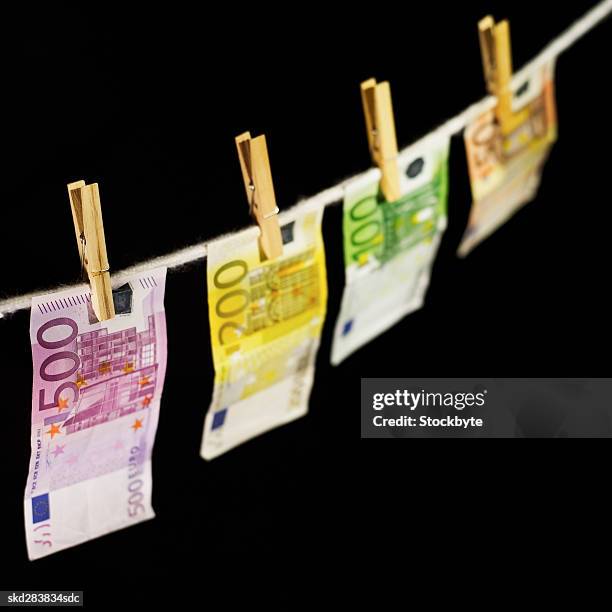 close-up of various euro notes hanging on clothesline - zweihunderteuroschein stock-fotos und bilder